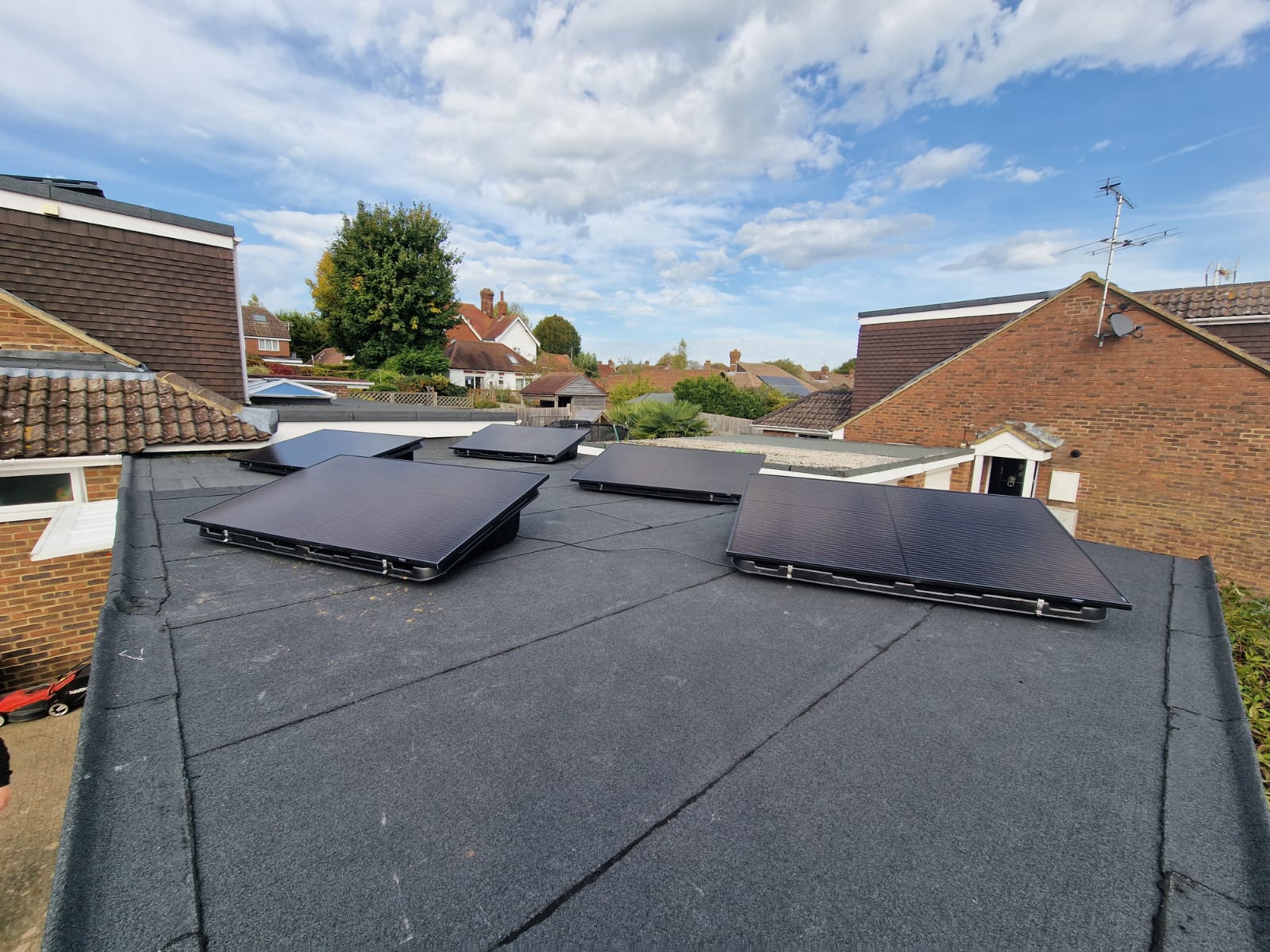 Solar panels mounted on a garage flat roof at a customer’s house